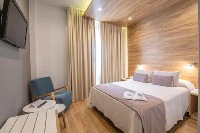 a hotel room with a bed and a tv at Hotel Monte Puertatierra in Cádiz