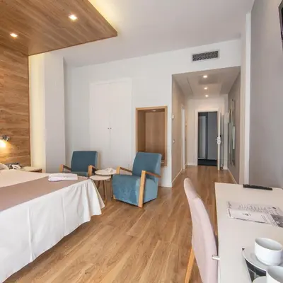 a hotel room with a bed and chairs and a table at Hotel Monte Puertatierra in Cádiz