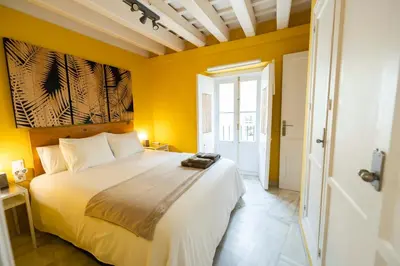 a bedroom with a large bed with yellow walls at Apartamento 