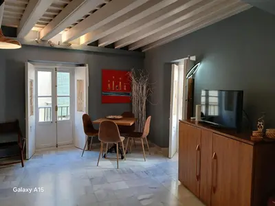 a dining room with a table and chairs and a television at Apartamento 