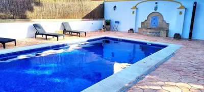 a swimming pool with two chairs next to a building at casa de vicky in El Puerto de Santa María