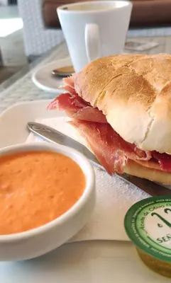 a sandwich on a plate with a bowl of soup at casa de vicky in El Puerto de Santa María