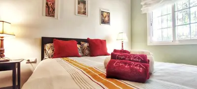 a bedroom with a bed with red pillows on it at casa de vicky in El Puerto de Santa María