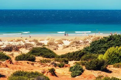 a group of people on a beach near the ocean at P Casa con Azotea privada y Céntrica. WiFi+Netflix in El Puerto de Santa María