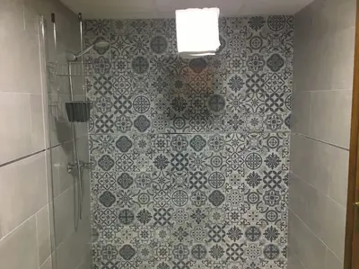 a bathroom with a shower with blue and white tiles at Moderno apartamento en Bahia Sur in San Fernando