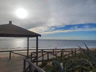 a beach with a gazebo and the ocean at Precioso bajo muy grande a 200 metros de playa in Chipiona