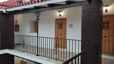 a balcony with a black railing and a wooden door at Apartamento la Buganvilla in Jerez de la Frontera