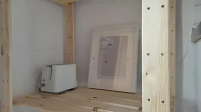 a room with a refrigerator and a television on a wooden floor at Apartamento la Buganvilla in Jerez de la Frontera