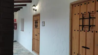 a hallway with two wooden doors in a building at Apartamento la Buganvilla in Jerez de la Frontera