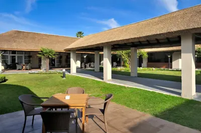 a patio with a table and chairs and a building at Vincci Resort Costa Golf in Chiclana de la Frontera