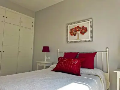a bedroom with a bed with red pillows at Apartamento La Catedral - Ole Solutions in Jerez de la Frontera