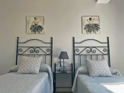 a bedroom with two beds and two pictures on the wall at Apartamento La Catedral - Ole Solutions in Jerez de la Frontera