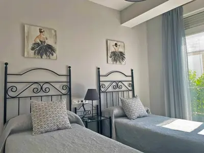a bedroom with two beds and a window at Apartamento La Catedral - Ole Solutions in Jerez de la Frontera