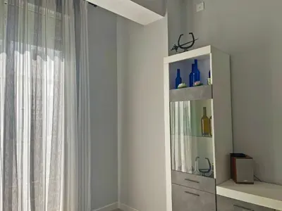 a white cabinet with blue bottles on it next to a window at Apartamento La Catedral - Ole Solutions in Jerez de la Frontera