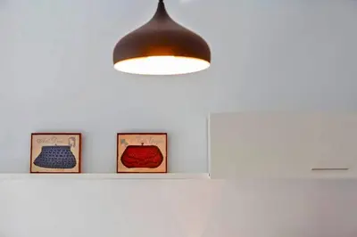 a light hanging from a ceiling with three pictures on a shelf at La Torre de la Catedral - Ole Solutions in Jerez de la Frontera