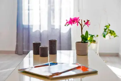 a table with a pink flower in a vase on it at La Torre de la Catedral - Ole Solutions in Jerez de la Frontera