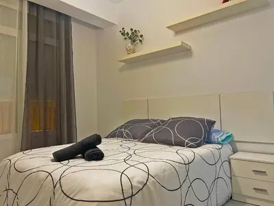 a bedroom with a bed with a black and white comforter at La Torre de la Catedral - Ole Solutions in Jerez de la Frontera
