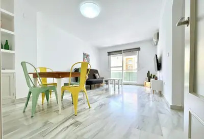 a dining room and living room with a table and chairs at Apartamento Plaza Toros in El Puerto de Santa María