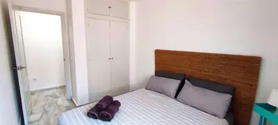 a bedroom with a bed with a wooden headboard at Apartamento Plaza Toros in El Puerto de Santa María