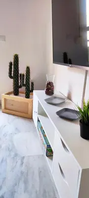 a white desk with a cactus and a tv at Apartamento Plaza Toros in El Puerto de Santa María