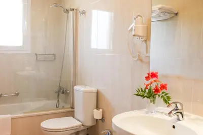 a bathroom with a toilet and a sink and a shower at Hotel Dunas Puerto in El Puerto de Santa María