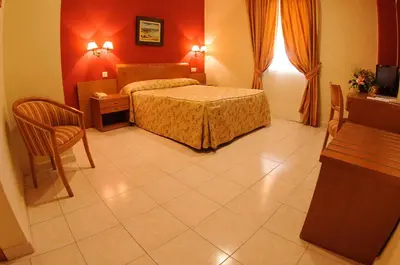 a bedroom with a bed and a table and chairs at Hotel Dunas Puerto in El Puerto de Santa María