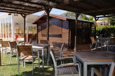 a patio with tables and chairs and a building at Hotel Dunas Puerto in El Puerto de Santa María
