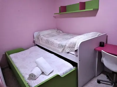 a small room with two bunk beds and a desk at Piso Calzada de la Infanta Tres Carabelas Sanlúcar de Barrameda in Sanlúcar de Barrameda