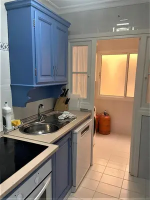 a kitchen with blue cabinets and a sink at Piso Calzada de la Infanta Tres Carabelas Sanlúcar de Barrameda in Sanlúcar de Barrameda