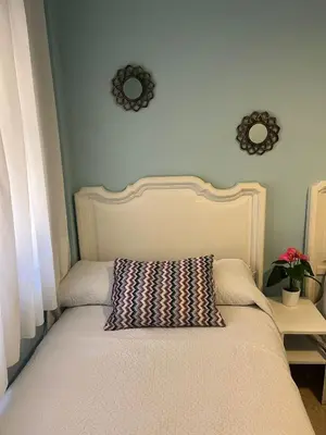 a bed with a pillow on it in a bedroom at Piso Calzada de la Infanta Tres Carabelas Sanlúcar de Barrameda in Sanlúcar de Barrameda