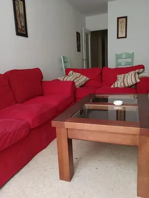 a living room with red couches and a coffee table at Piso Calzada de la Infanta Tres Carabelas Sanlúcar de Barrameda in Sanlúcar de Barrameda