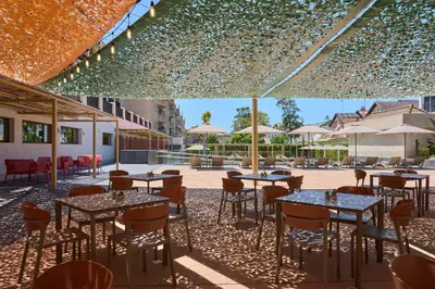 a restaurant with tables and chairs in a courtyard at Hotel Macià Doñana in Sanlúcar de Barrameda