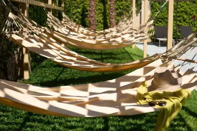 two hammocks sitting in the grass in a yard at Hotel Macià Doñana in Sanlúcar de Barrameda