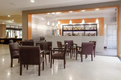 a restaurant with tables and chairs and a bar at Hotel Macià Doñana in Sanlúcar de Barrameda