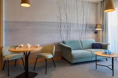 a living room with a couch and a table and chairs at Hotel Macià Doñana in Sanlúcar de Barrameda