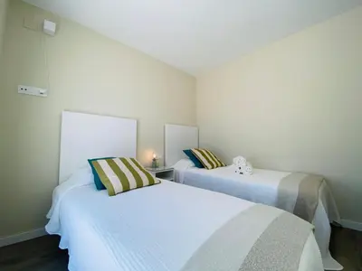 two beds in a small room with white walls at Summerlandrota Argüelles 4 in Rota