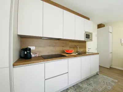 a kitchen with white cabinets and a sink at Summerlandrota Argüelles 4 in Rota