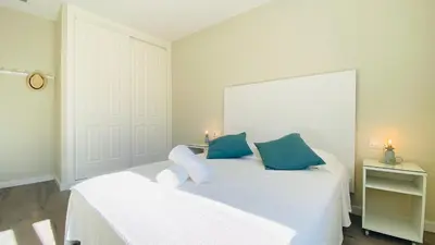 a bedroom with two beds with blue and white pillows at Summerlandrota Argüelles 4 in Rota