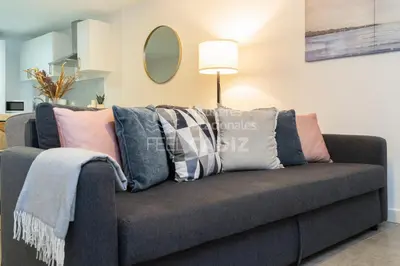 a couch with pillows on it in a living room at Apartamento El Mirador del Paso (Feel Cádiz) in Cádiz