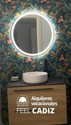 a bathroom with a mirror and a sink on a counter at Apartamento El Mirador del Paso (Feel Cádiz) in Cádiz