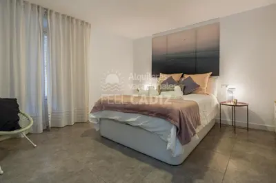 a bedroom with a large bed with a large headboard at Apartamento El Mirador del Paso (Feel Cádiz) in Cádiz