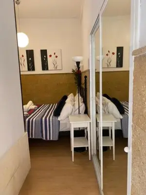 a bedroom with a bed with a mirror and a table at EL RINCON DE ELENA (CASCO HISTORICO) in Jerez de la Frontera