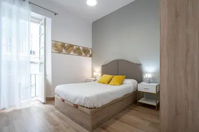a bedroom with a bed with yellow pillows on it at El Balcon de la Viña by Cadiz Time in Cádiz