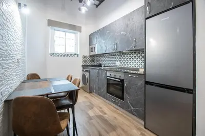 a kitchen with a table and a refrigerator at El Balcon de la Viña by Cadiz Time in Cádiz