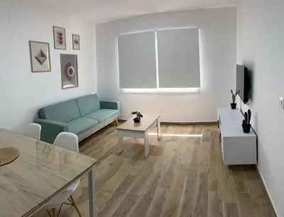 a living room with a blue couch and a table at Fantástico piso reformado zona centro San Miguel in Jerez de la Frontera