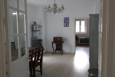 a living room with a dining room table and a chandelier at Ático en La Candelaria in Cádiz
