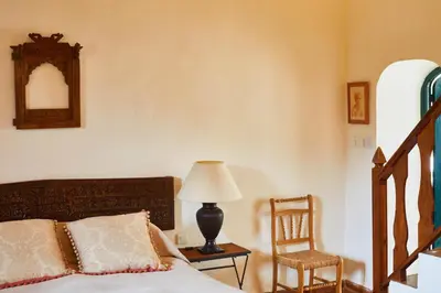 a bedroom with a bed and a chair and a lamp at Hacienda de San Rafael in Las Cabezas de San Juan