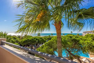 a palm tree on the balcony of a resort at Valentin Sancti Petri in Chiclana de la Frontera