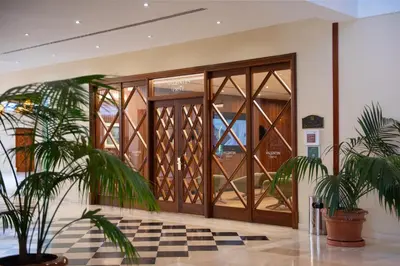 a glass door in a lobby with potted plants at Valentin Sancti Petri in Chiclana de la Frontera