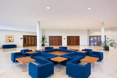 a large lobby with blue chairs and tables at Valentin Sancti Petri in Chiclana de la Frontera